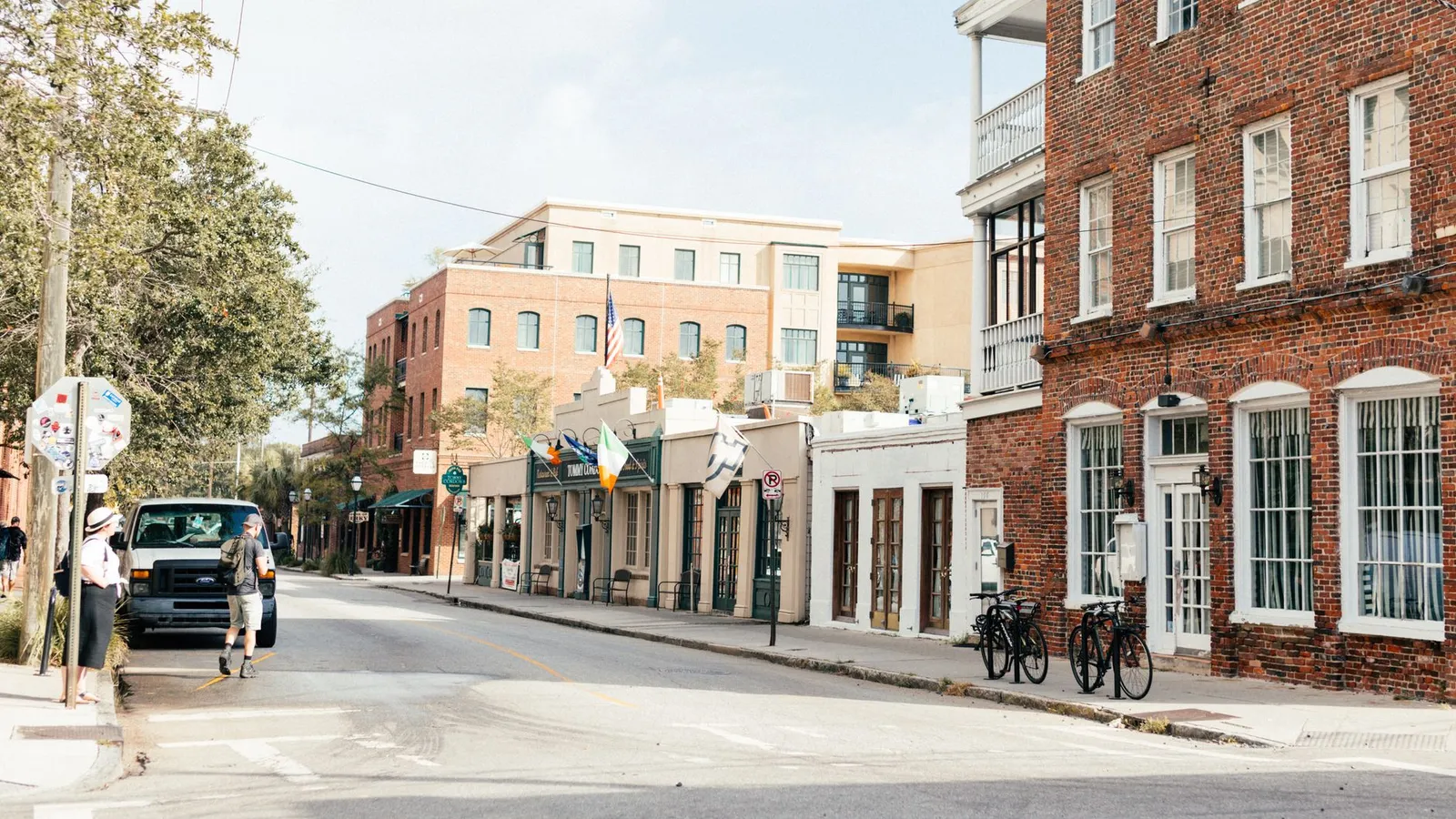 Scenic view of an urban street lined with historic brick buildings and parked bicycles on a sunny day.