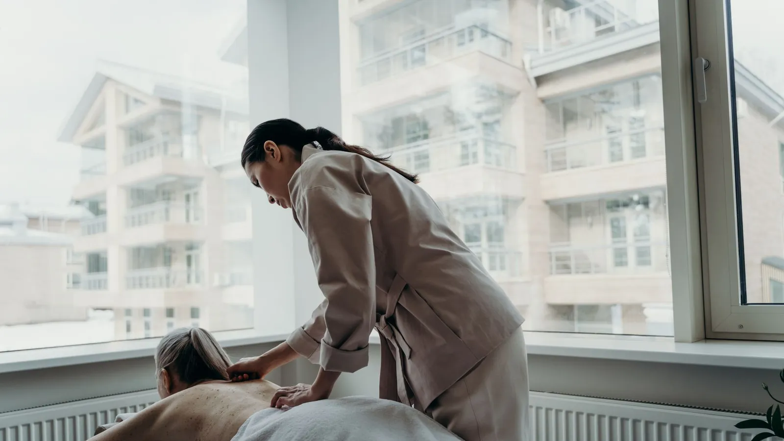 Woman receiving a back massage in a spa, promoting relaxation and wellness.