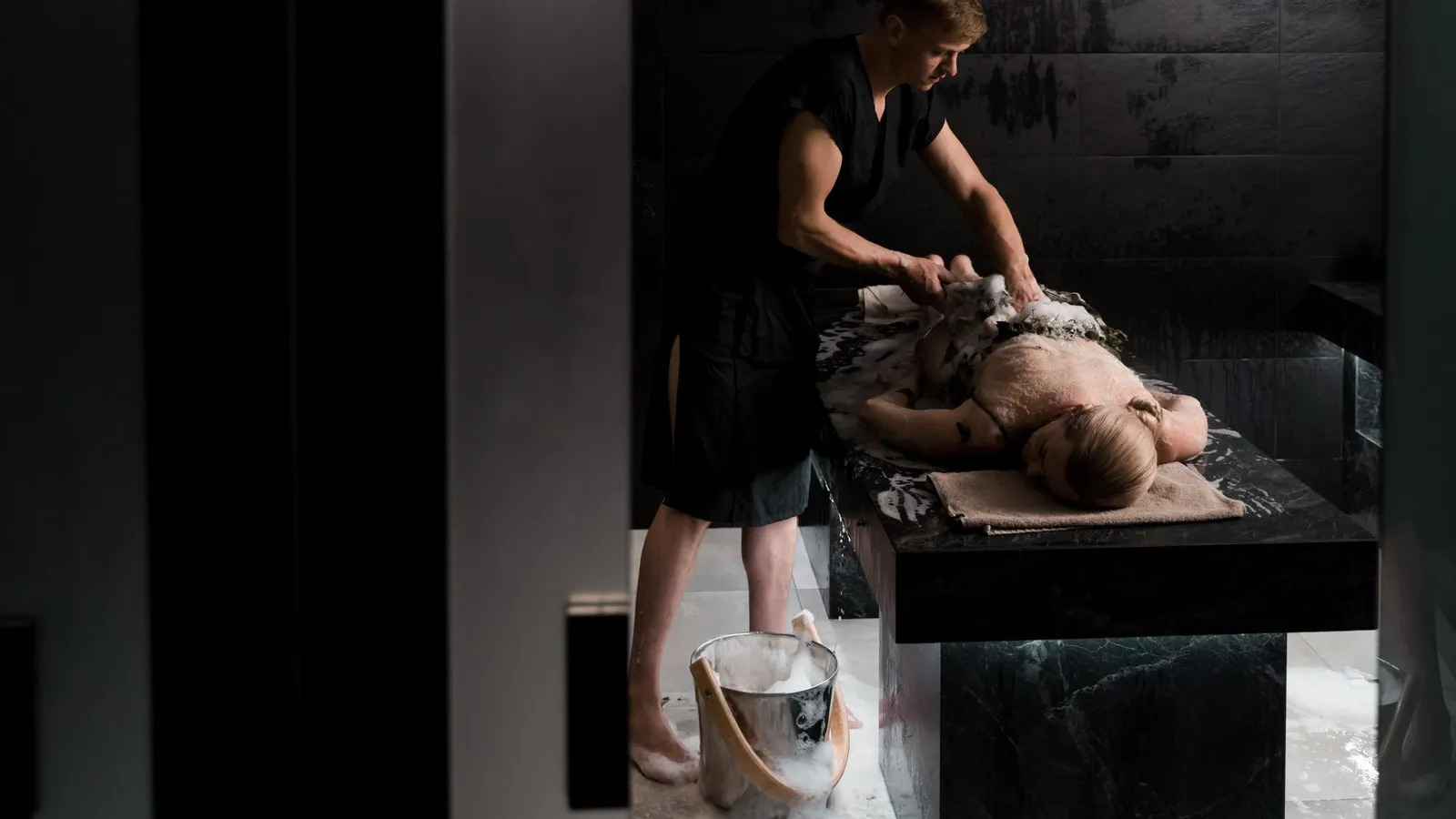 A professional giving a soothing soap massage in a relaxing spa environment, promoting relaxation and wellness.